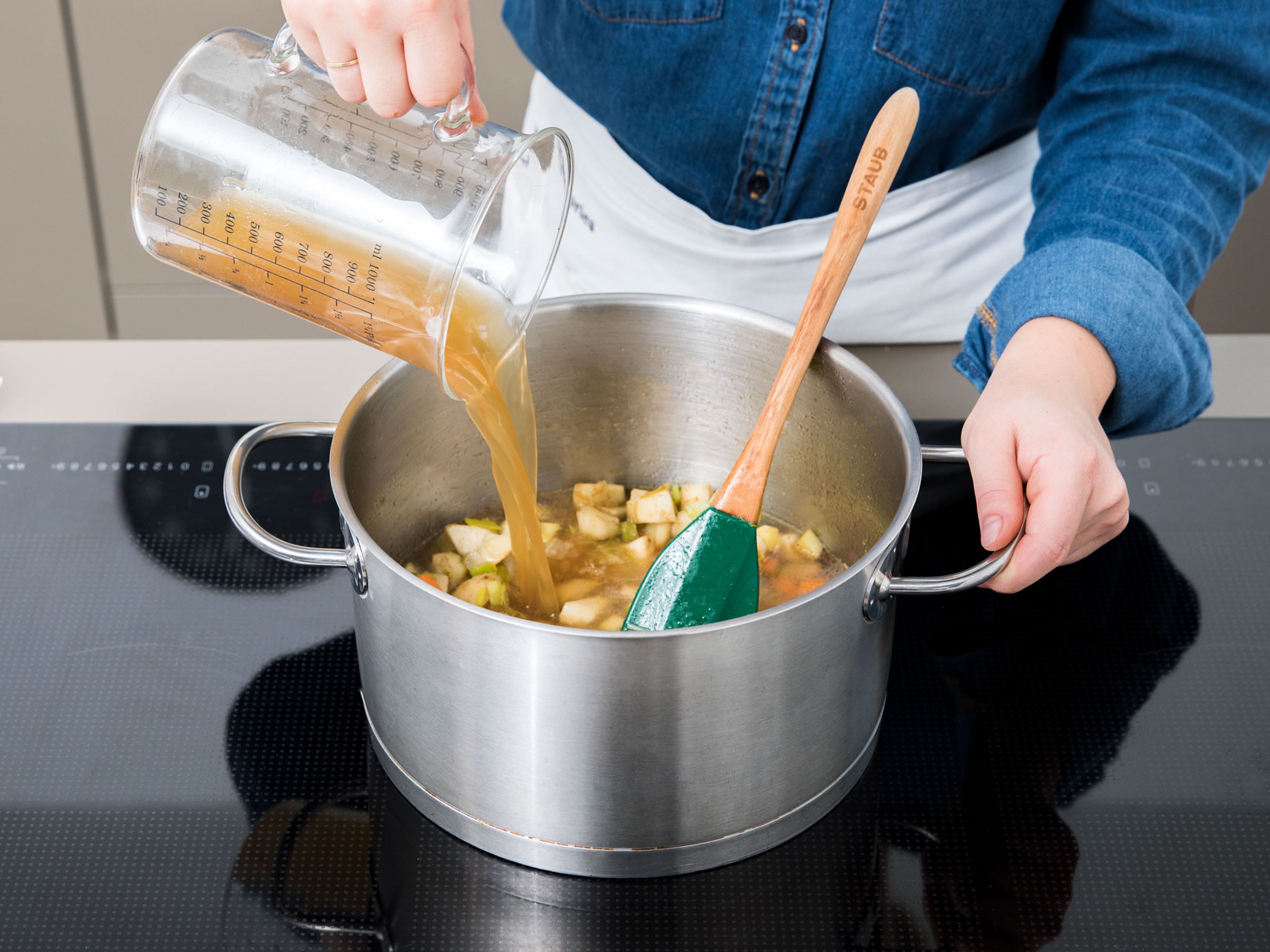 Mit Gemüsebrühe auffüllen und zum Kochen bringen. Die Temperatur auf niedrige bis mittlere Stufe reduzieren und ca. 20 Min. ohne Deckel köcheln lassen.