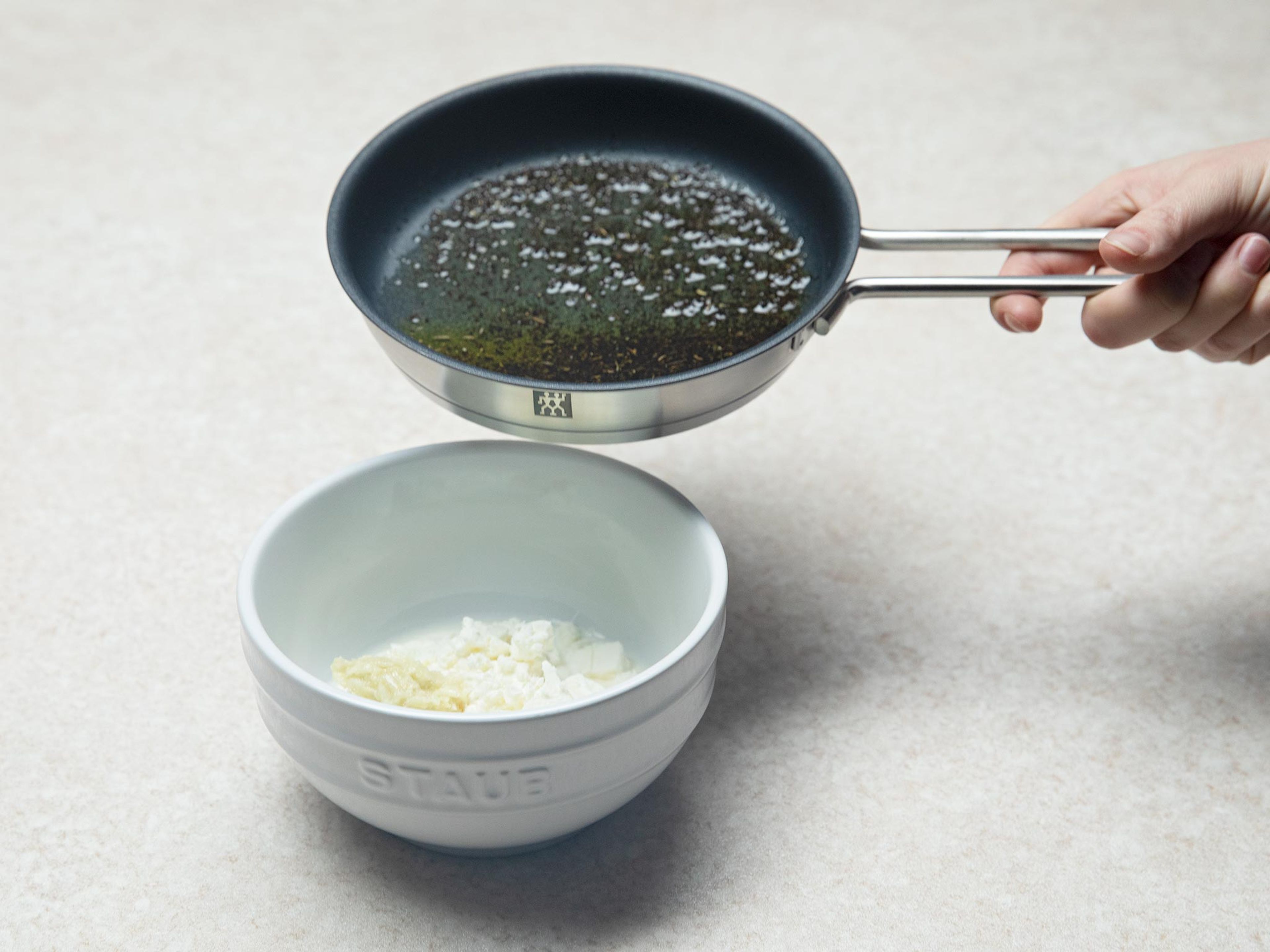 Olivenöl und getrocknete Minze ca. 1 Min. in einer Pfanne über mittlerer Hitze erwärmen. Danach beiseitestellen. Knoblauch mit einer Prise Salz in einem Mörser zu einer Paste zerstoßen. Warmes Minzöl, Knoblauchpaste, Fetakäse und griechischen Joghurt in eine Schüssel geben und vermengen. Simit mit dem Knoblauch-Minz-Dip servieren. Guten Appetit!