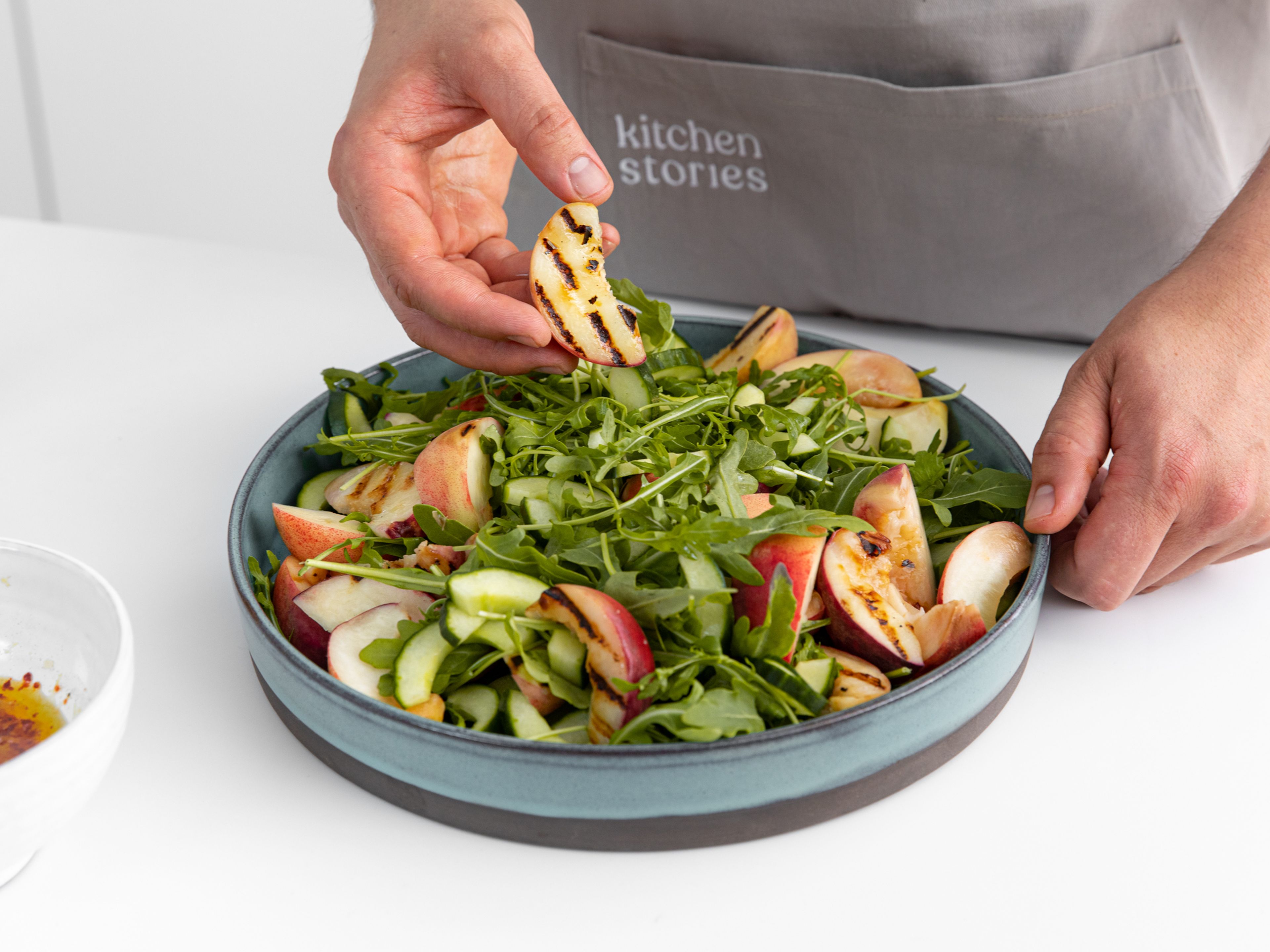 Arrange the arugula on a large serving plate, then add cucumber, zucchini, and peaches. Tear the mozzarella over the top and drizzle the dressing over the salad. Sprinkle marjoram all over and serve immediately. Enjoy!