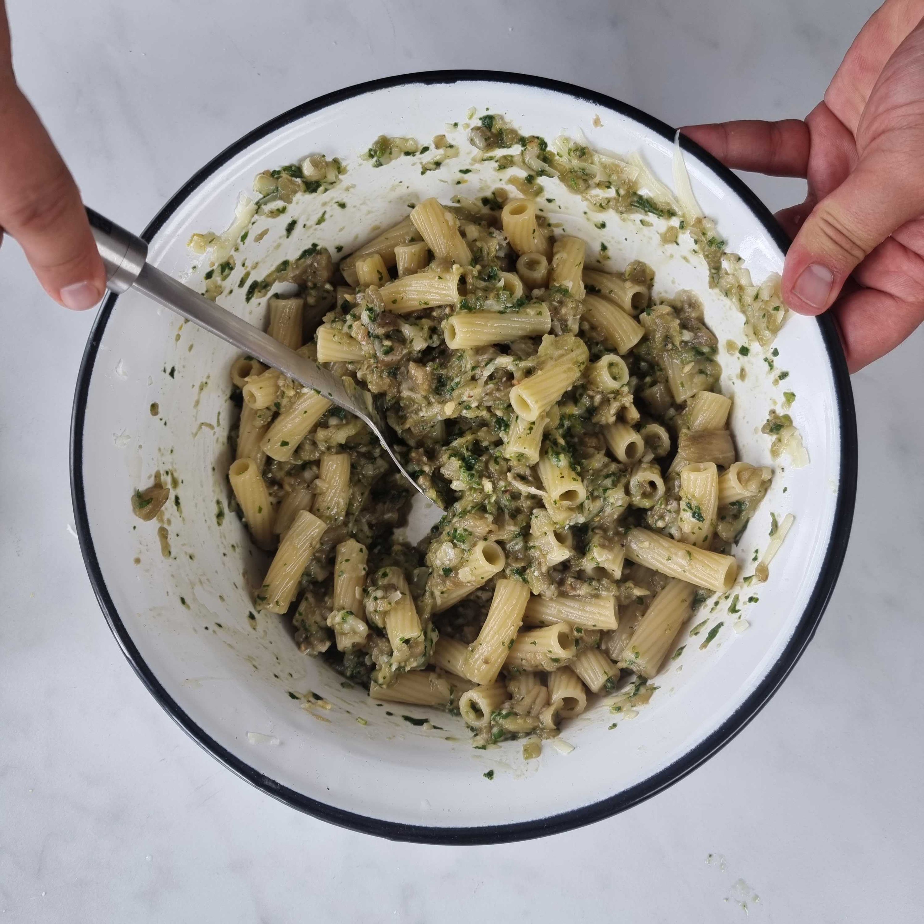 Die Nudeln abkippen und etwas Pastawasser aufbewahren. Die Pasta nun zusammen mit dem Käse zu der Aubergine geben und alles gut verrühren. Für die Konsistenz etwas Pastawasser dazugeben und mit Salz abschmecken.
