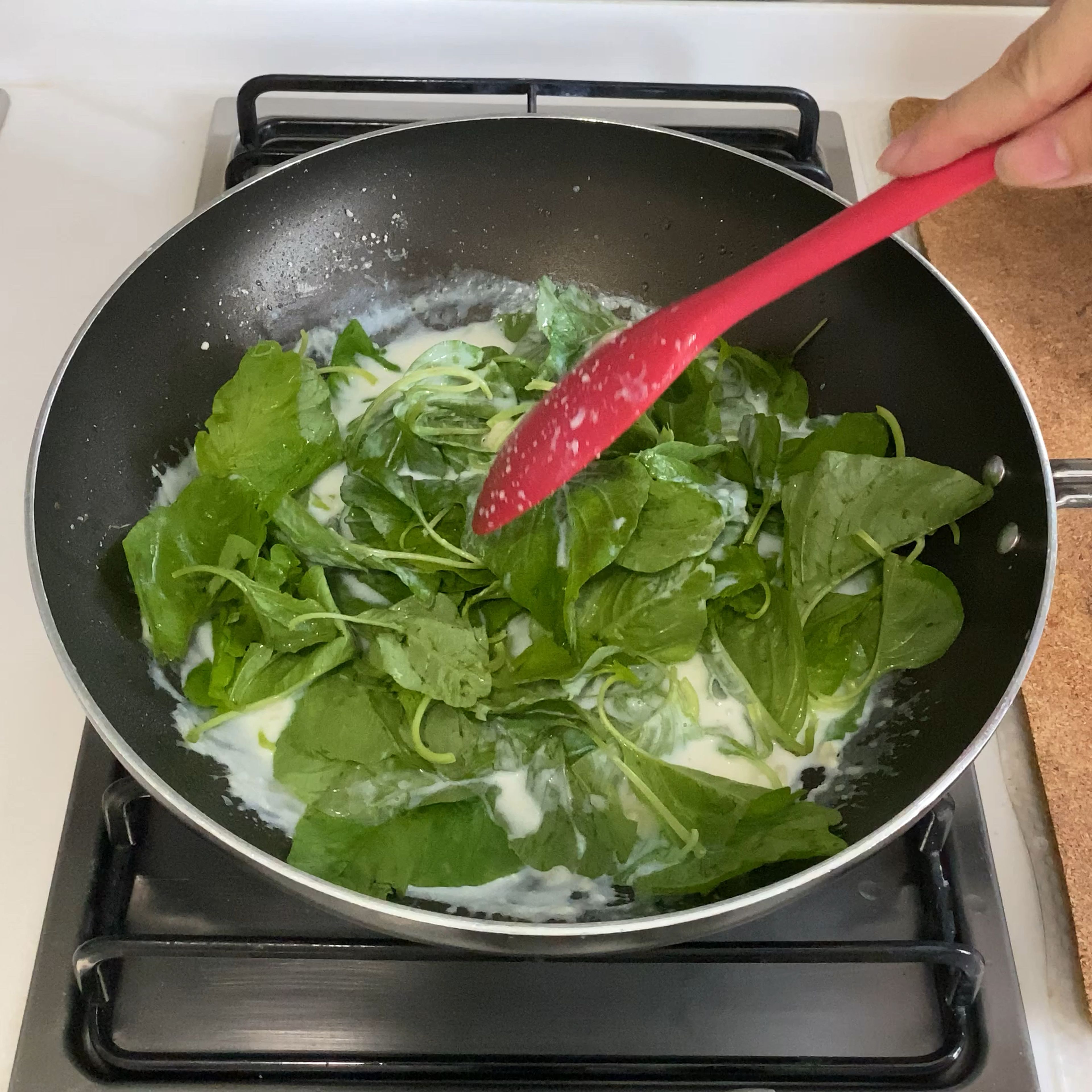 Nun die Butter in die Pfanne geben. Den Knoblauch anbraten, Mehl hinzufügen und gut vermengen. Die Milch hinzugeben und verrühren, bis sie cremig wird. Nun den Spinat hinzufügen. Mit Knoblauchpulver, Salz, Pfeffer und Brühwürfel würzen. Alles für ca. 2-3 Min. kochen lassen.