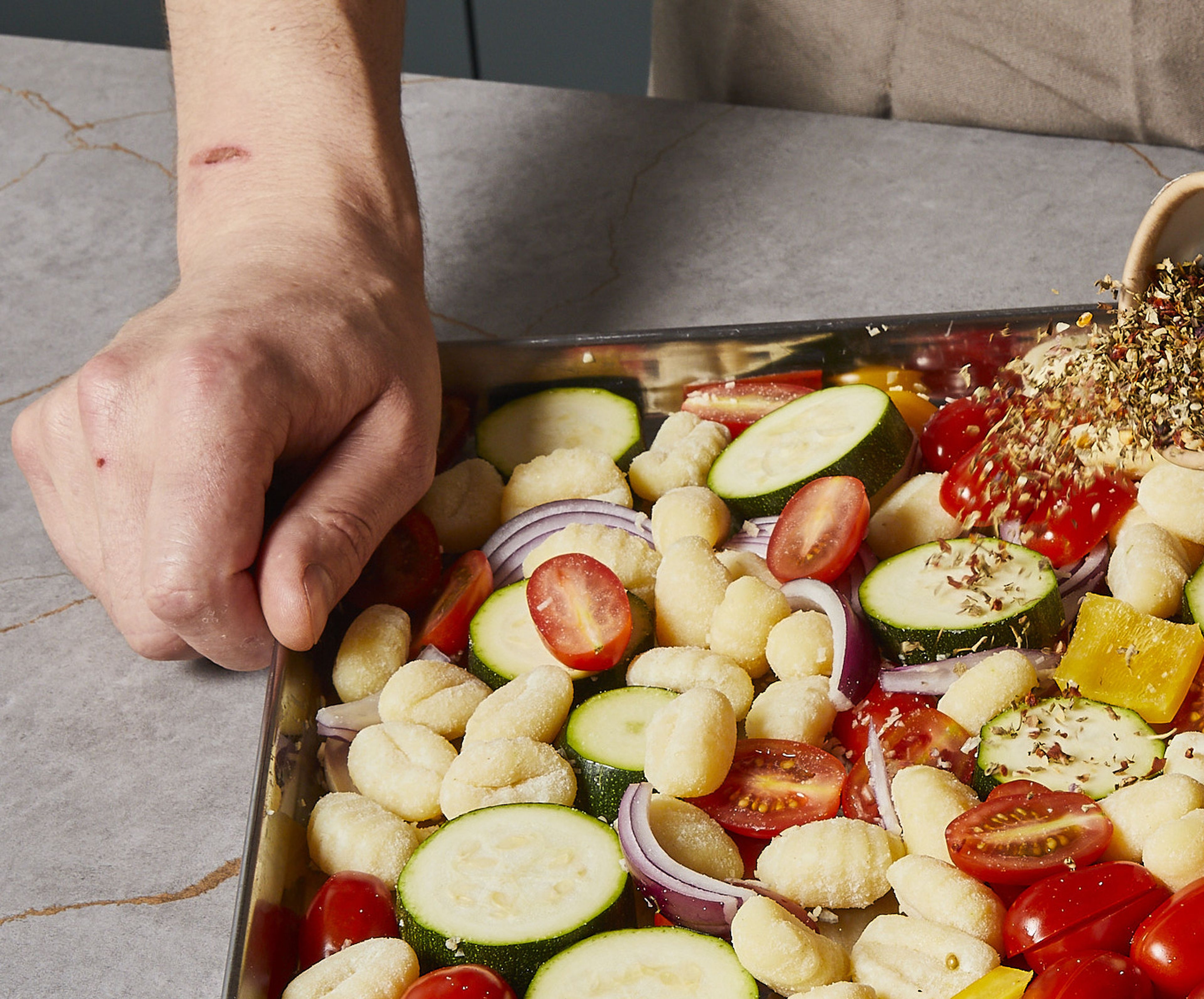 Spread gnocchi, onion, zucchini, bell pepper and cherry tomatoes on an air fryer liner with the air fryer parchment paper on it. Press the garlic cloves over the vegetables. Sprinkle dried basil, thyme, oregano, and chili flakes over everything and drizzle with half of the olive oil and balsamic vinegar. Season with salt and pepper, mix everything well and bake in the air fryer for approx. 15–20 min. at 180°C/356°F. Toss around twice within the duration.