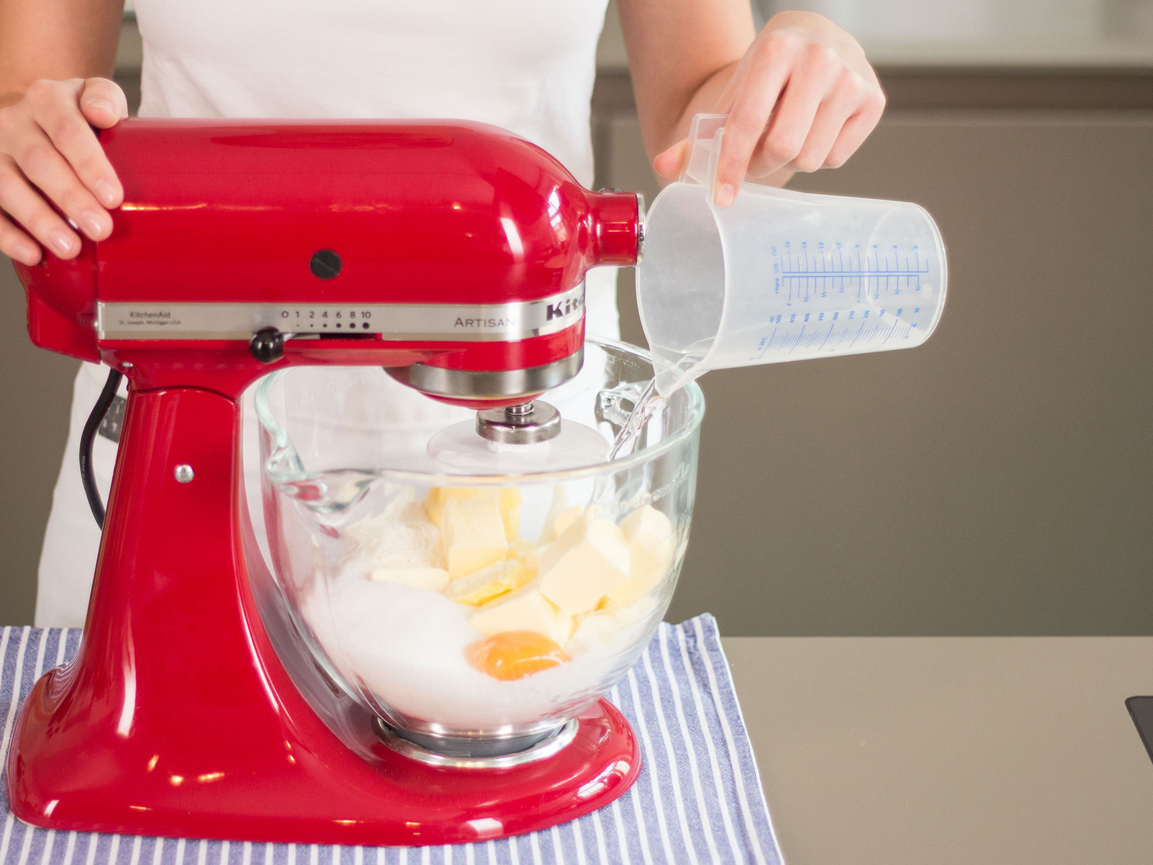 Cut some of butter into large pieces and add to a stand mixer with most of flour, egg yolk, salt, and sugar. Beat for approx. 2–3 min. until crumbly. Then, slowly add water and continue to beat for another 1–2 min. until dough is smooth and uniform in consistency. Wrap dough in plastic wrap and transfer to refrigerator. Allow to set for approx. 1 h.
