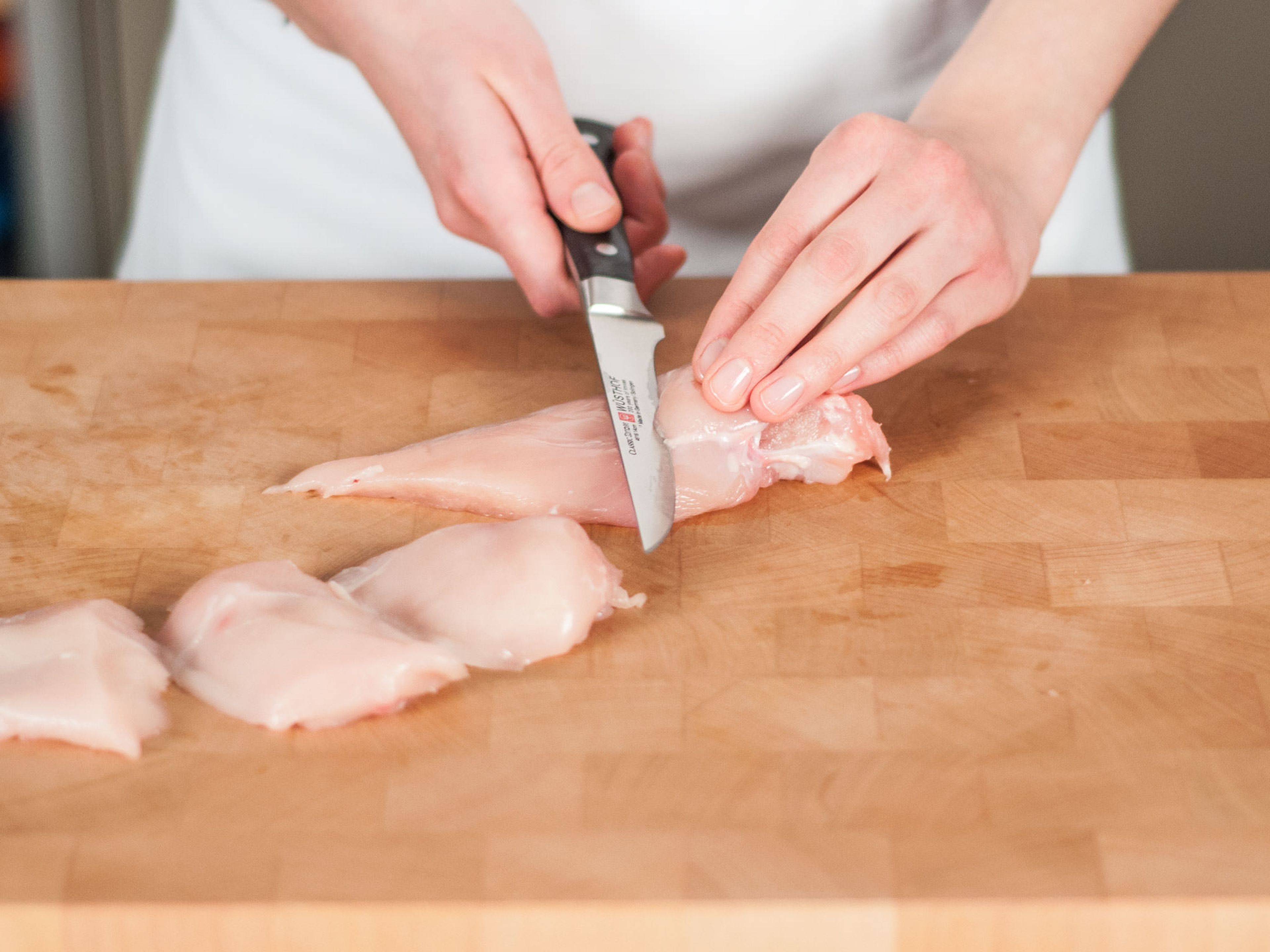 Finely dice onion. Cut each chicken breast into three equal-sized pieces.
