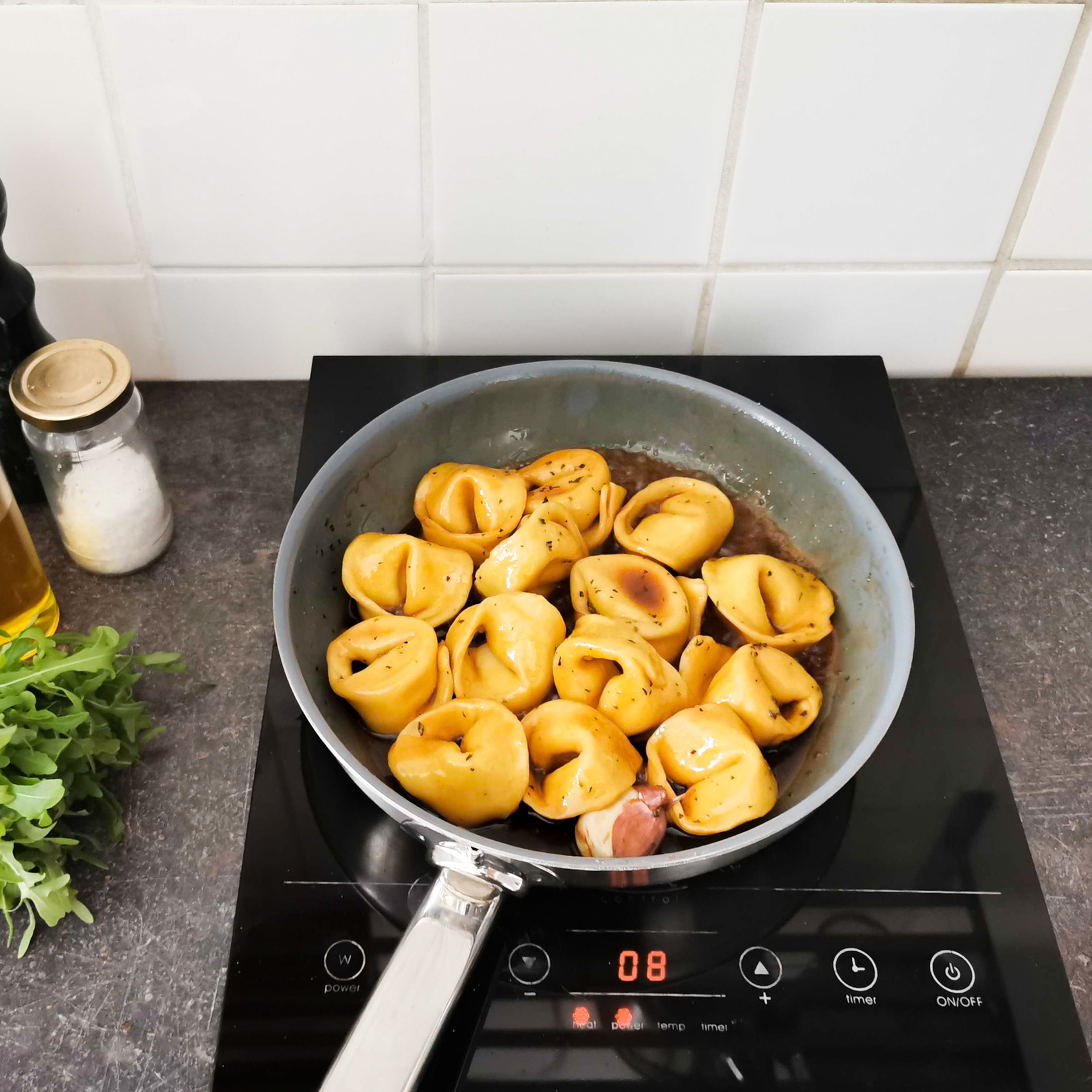 Crush the garlic, leaving the skin on. Finely chop the rosemary and thyme. Caramelize sugar in a large pan, then deglaze with balsamic vinegar and let reduce for approx. 2 min. Add garlic, herbs, butter, some pasta water, salt, and pepper, and bring to a simmer. Add tortellini to the sauce, tossing gently to coat in the sauce. Plate, then sprinkle arugula over and drizzle with more olive oil, if desired. Serve immediately and enjoy!