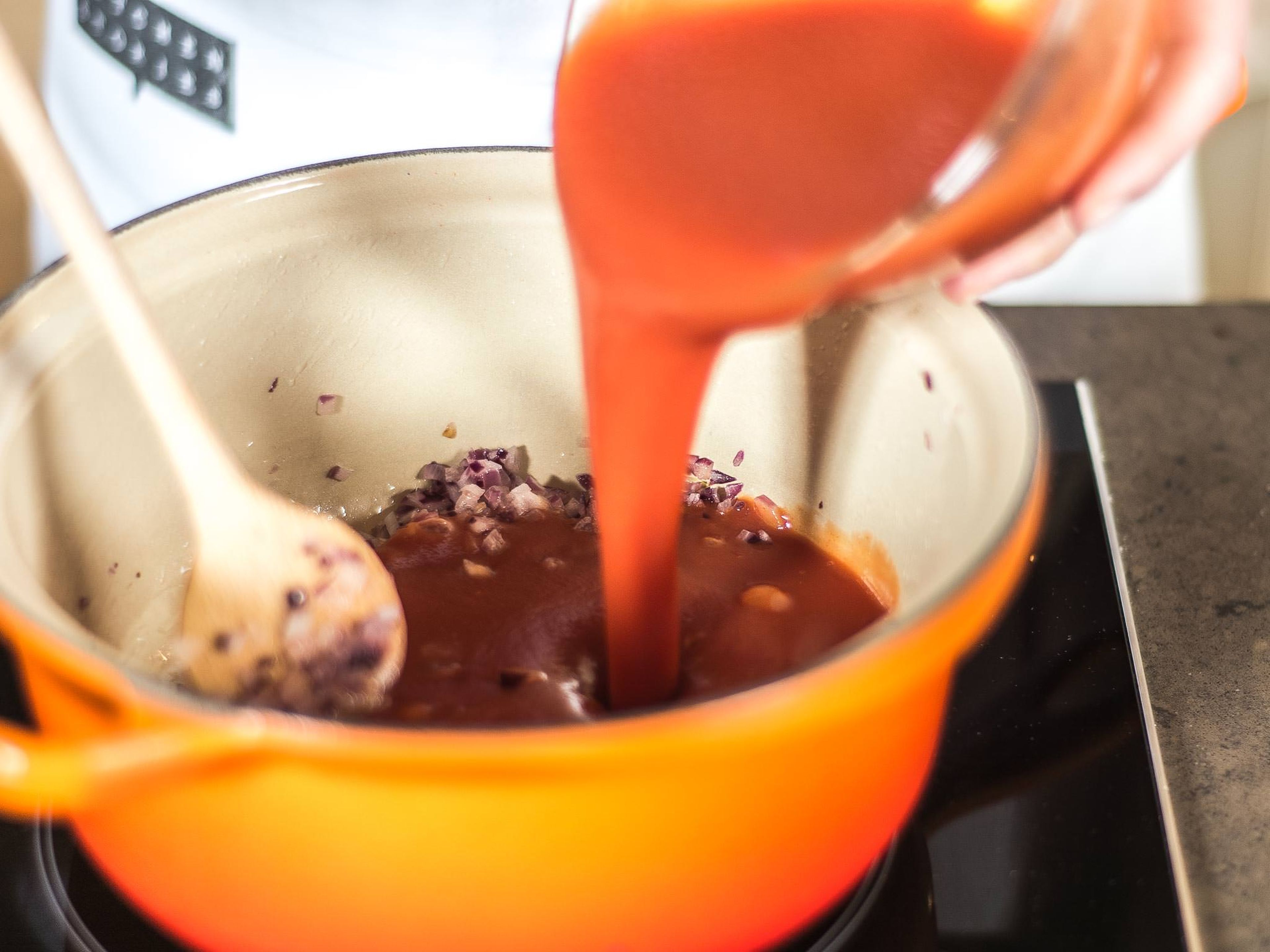 Zwiebel und Knoblauch in Pflanzenöl glasig anschwitzen. Mit den passierten Tomaten aufgießen und mit dem übrigen Zucker, Salz und Pfeffer würzen. Die Soße ca. 5–7 Min. bei niedriger Hitze einkochen lassen.