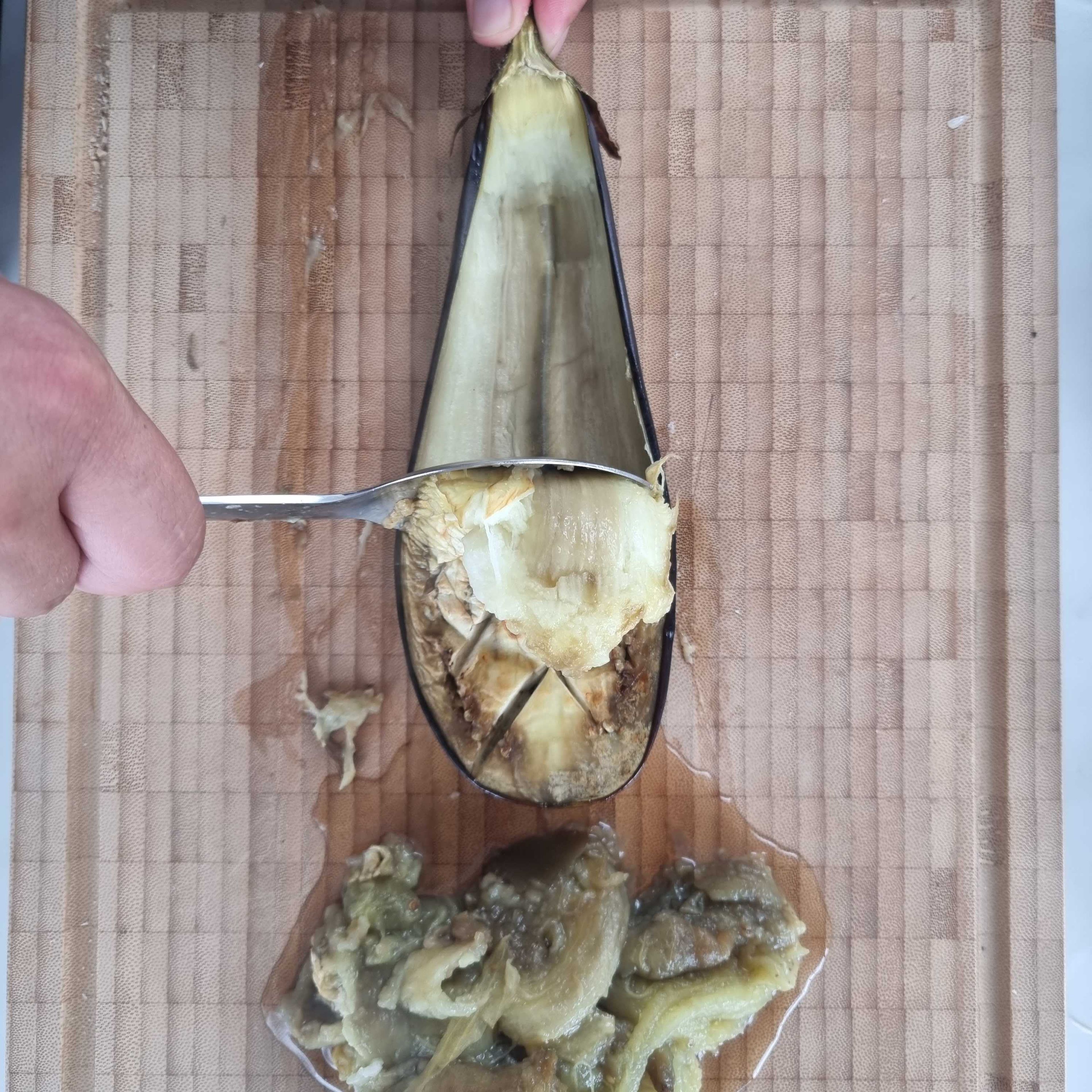 Die Auberginen aus dem Ofen holen und das Fruchtfleisch mit einem Löffel herauskratzen. Dann die Aubergine mit einem Messer fein hacken und mit in die große Schüssel füllen. Die Nudeln nach Packungsanweisung in gesalzenem Wasser kochen.