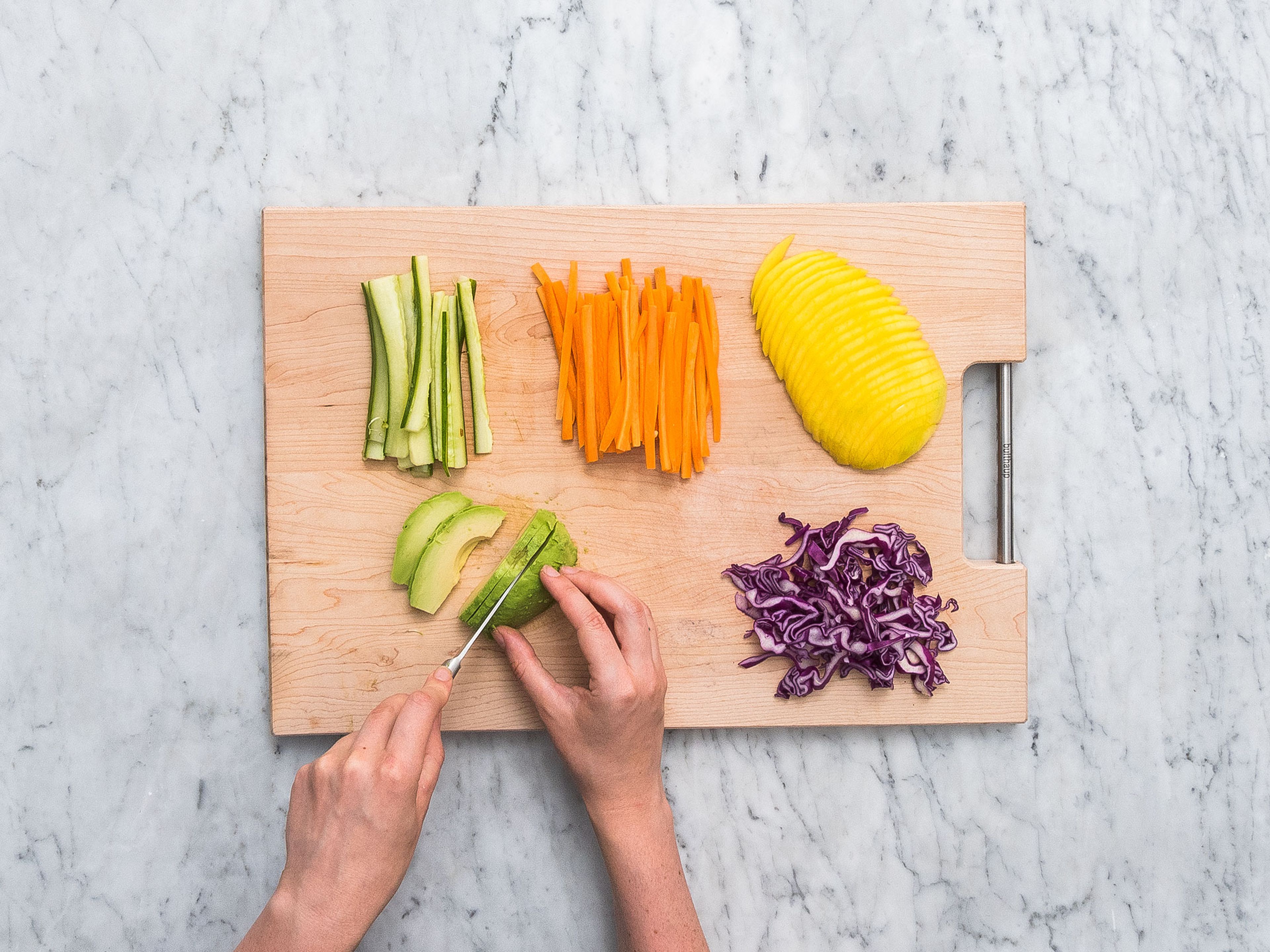 Karotten schälen und in dünne Streifen schneiden. Gurke und Rotkohl ebenfalls Julienne schneiden. Mango, Radieschen und Avocado in feine Scheiben schneiden. Kresse etwas kürzen.