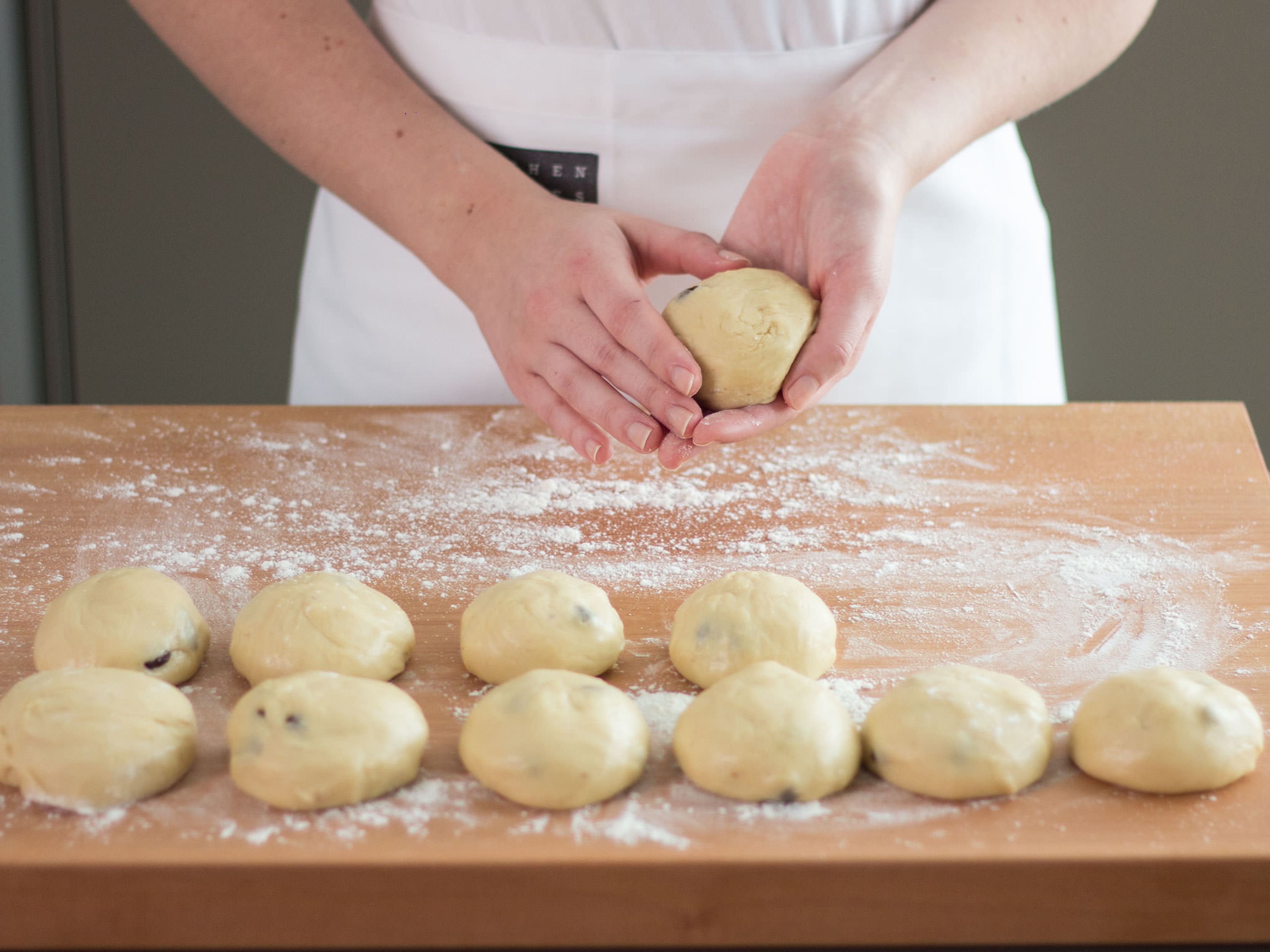Den Teig auf einer mit Mehl bestäubten Arbeitsfläche ausrollen und zu runden Brötchen formen. Auf ein mit Backpapier ausgelegtes Backblech legen und für weitere ca. 30 Min. ruhen lassen.
