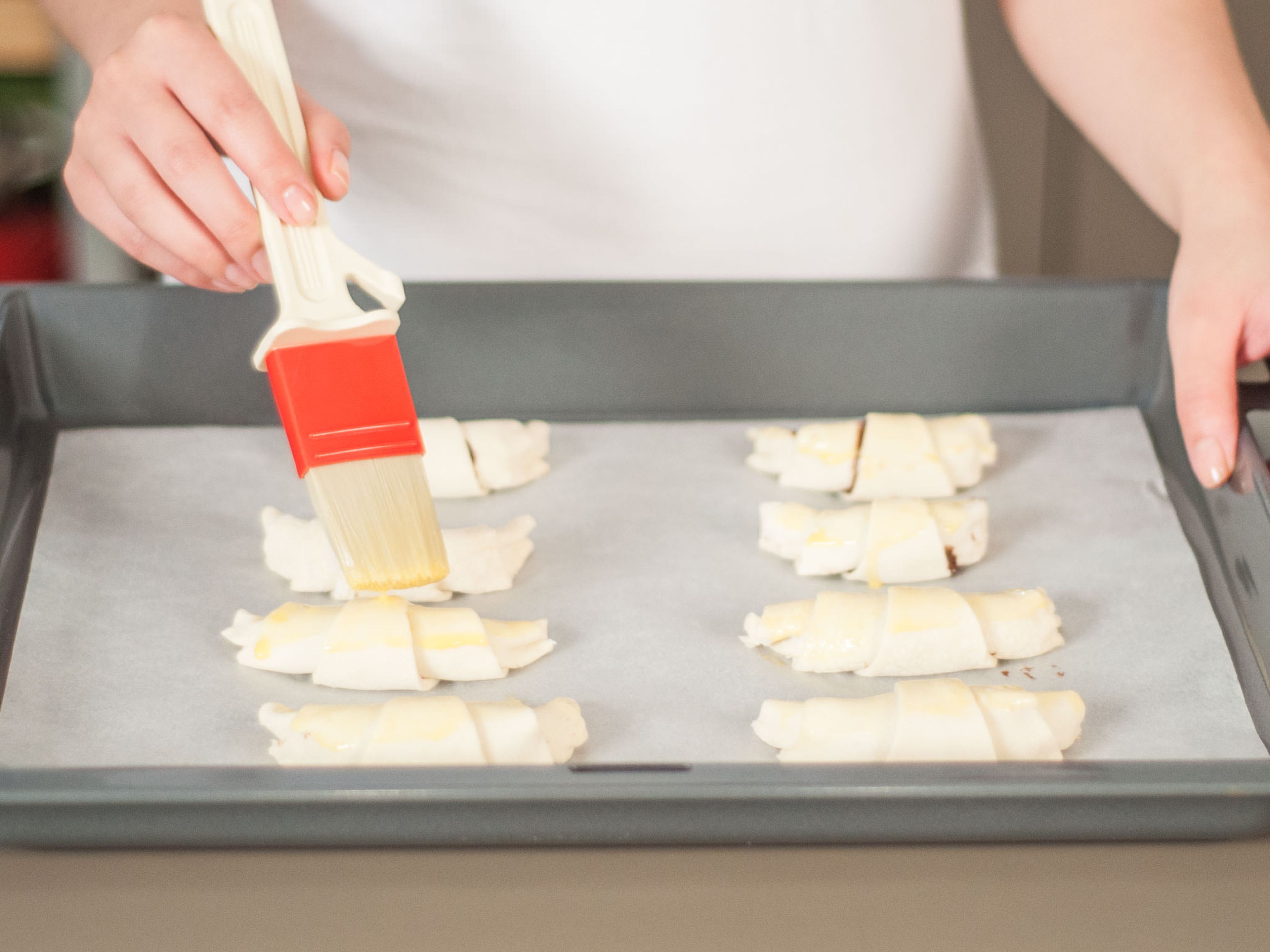 Ei verquirlen. Die Croissants auf ein mit Backpapier ausgelegtes Backblech legen und leicht mit Ei bestreichen. In den Ofen schieben und für ca. 8 – 10 Min. backen, bis sie goldbraun sind. Zum Frühstück oder als Kleinigkeit am Nachmittag genießen.