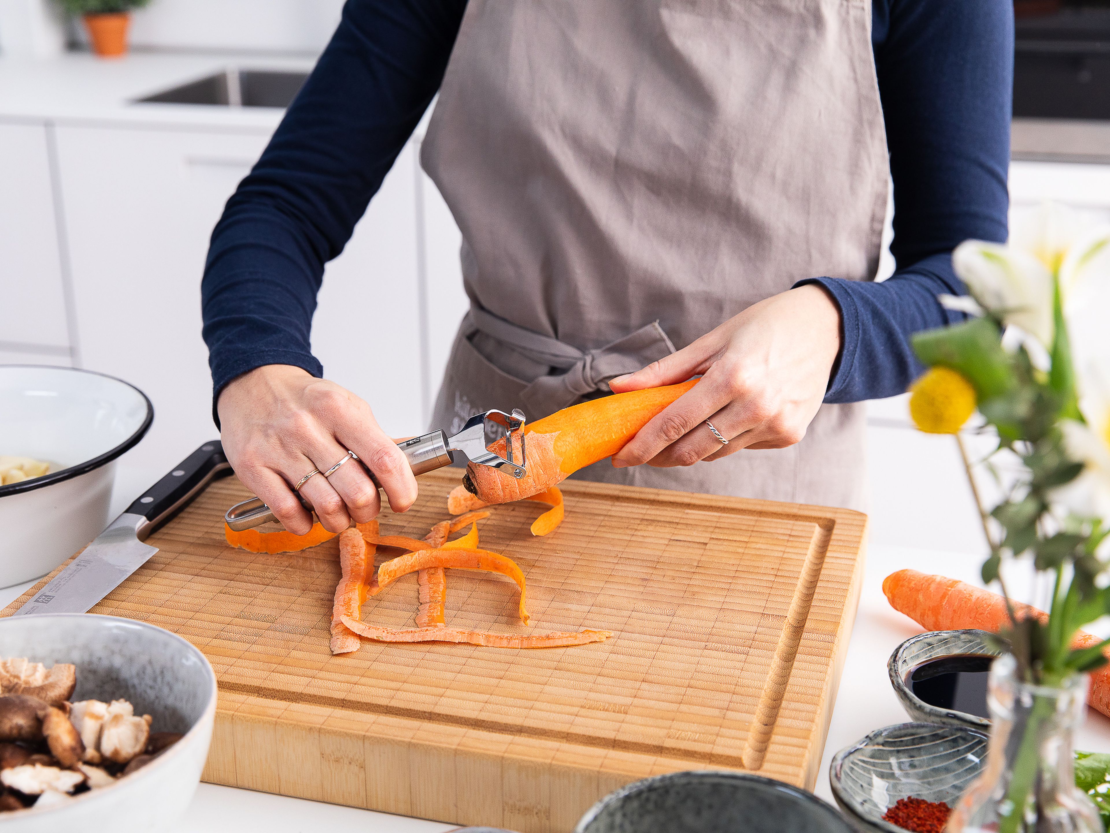 Die Stiele der Pilze entfernen und vierteln. Die Karotten, Zwiebel und Knoblauch schälen. Die Pilze in einen Zerkleinerer geben und so lange pulsieren, bis sie grob gehackt sind. Danach in eine Schüssel geben. Die Karotten, Zwiebel und Knoblauch in den Zerkleinerer geben, ebenfalls grob zerkleinern und in eine Schüssel geben.