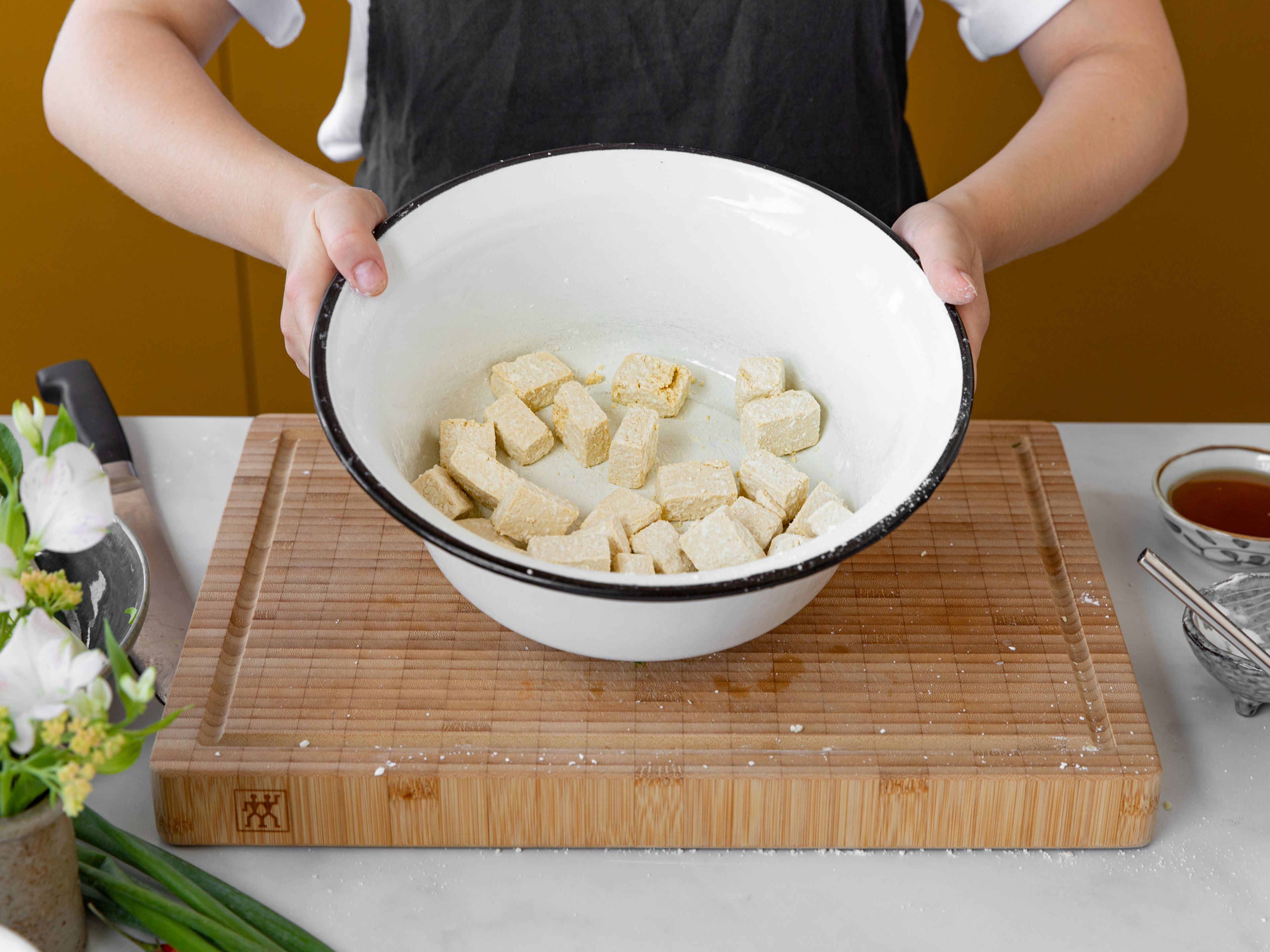 For the sauce, mix rice wine, soy sauce, water, and raw sugar in a small bowl. Pat tofu dry, then dice into bite-sized pieces. Add to a bowl with cornstarch and salt, and toss to coat.