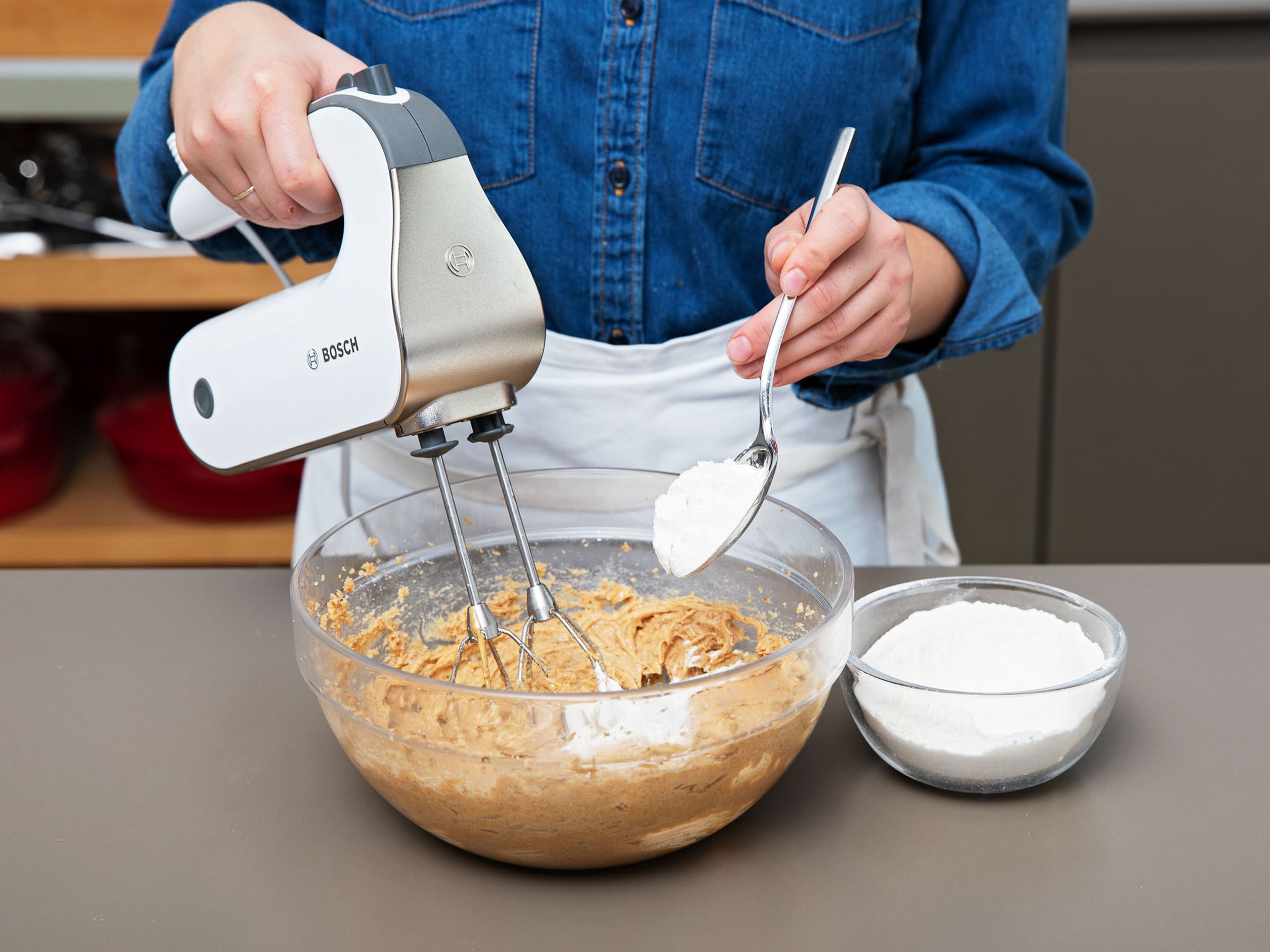 Restliches Mehl, Backnatron und Salz dazugeben und zu einem Teig vermengen. Restliche Schokotröpfchen unterrühren und auch diese Schüssel mit Frischhaltefolie bedeckt ca. 1 Std. im Kühlschrank ruhen lassen.