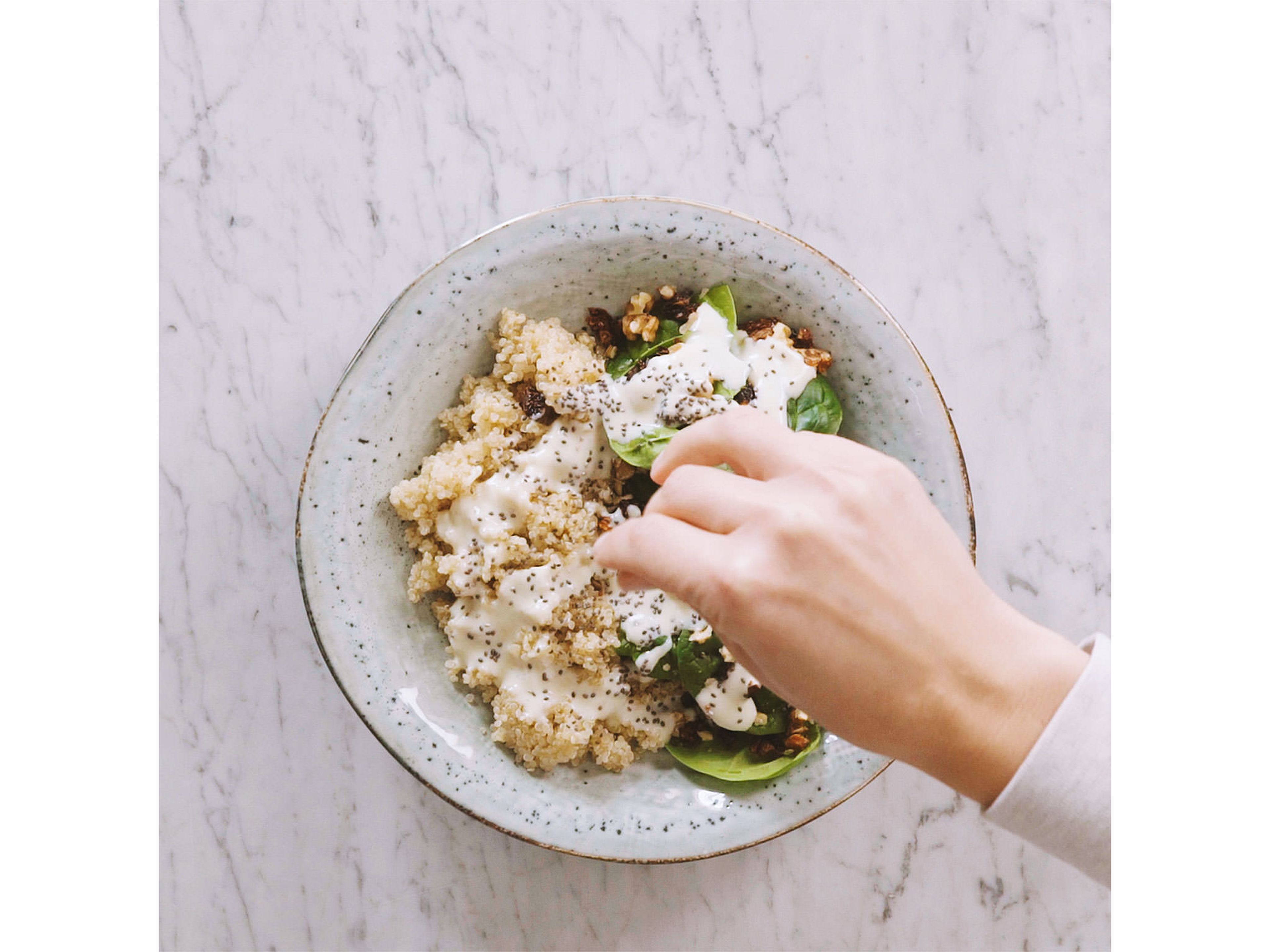 Gekochten Quinoa mit Babyspinat, gehackten Walnüsse und getrockneten Tomaten in die Servierschüssel geben. Mit Dressing und Chiasamen garniert genießen. Guten Appetit!